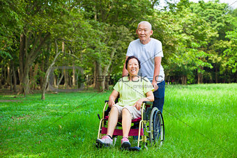 Asian senior woman sitting on a wheelchair with his husband