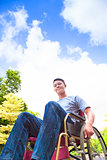  young man sitting on a wheelchair with natural background
