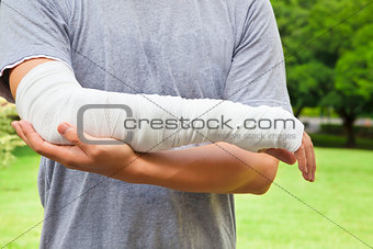 closeup of bandaged arm  with park background