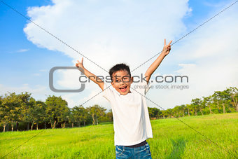 happy children standing on meadow and raise hands 