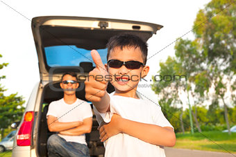 cool boy thumb up and father across arms with car 