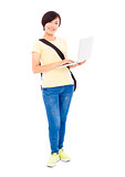 Smiling young woman holding a laptop and isolated on white