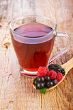 Fruit red tea with wild berries in wooden spoon