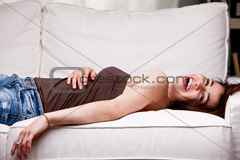 girl laughing on her sofa