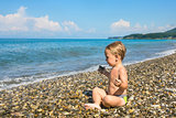 Baby boy in lotus pose on beach
