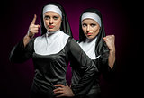 Two attractive young nuns indoors