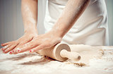 Woman rolling dough, close-up photo