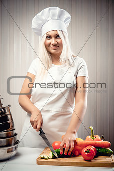 Woman wearing uniform cutting vegetables for a salad