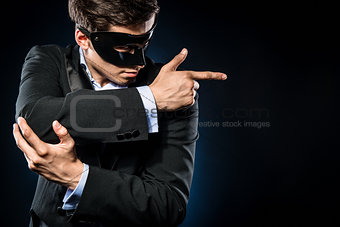Elegant man wearing black mask posing indoors