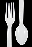 White plastic fork and spoon on black background.