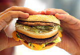 man's hands, holding onto a burger