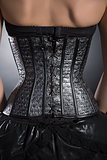 Back view of woman wearing silver leather corset 
