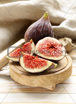 fresh ripe purple figs on wooden board