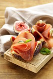 ripe purple figs with smoked ham - a traditional antipasti appetizer