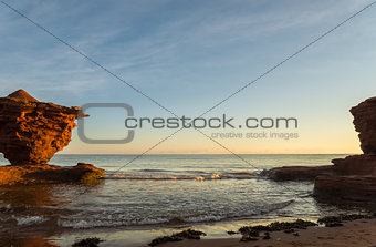 Red sandstone rocks at high tide