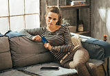 Thoughtful young woman with credit card and tablet pc sitting on