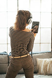 Young woman listening music in headphones in loft apartment. rea