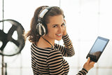 Portrait of happy young woman with tablet pc listening music in 
