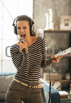Young woman with tablet pc singing karaoke