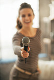 Closeup on young woman stretching microphone in camera