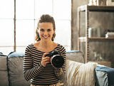 Portrait of happy young woman with modern dslr photo camera