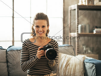 Portrait of happy young woman with modern dslr photo camera