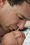 Father kissing infant son