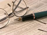 Pen and glasses on financial newspaper