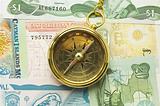 Old style gold compass with chain on money background