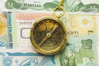 Old style gold compass with chain on money background