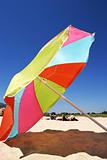 Large colourful umbrella on a sunny beach in Spain