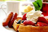 Blueberry waffles with strawberries and sausages