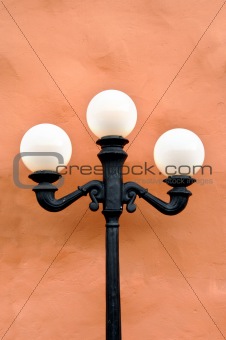Lamp Post stands in front of Stucco Building