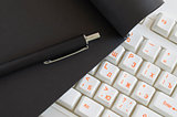 Workplace keyboard, notebook, pen,