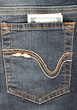 One hundred dollars in the back pocket of your jeans. Closeup.