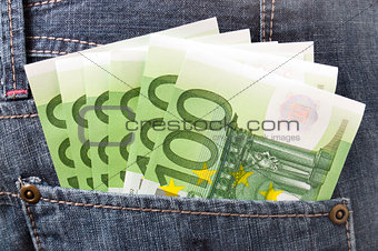 Euro banknotes in pocket of blue jeans trousers.