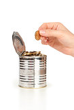 hand put coin in tin with coins, concept of savings or Donation