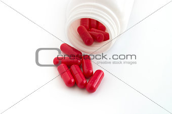 Pills spilling out of pill bottle isolated on white