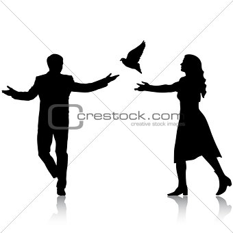 Concept of love or peace. Silhouettes girl and guy released dove