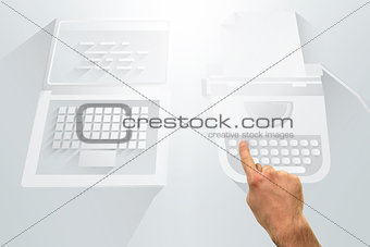 Hand pointing against laptop and typewriter