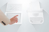 Businesswoman pointing against laptop and typewriter