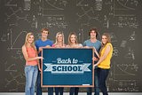 Group of people holding blackboard with message on wooden board