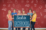 A group of people holding blackboard with message on wooden board