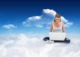 Composite image of cross-legged woman using a laptop