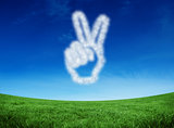 Composite image of cloud in shape of hand making peace sign