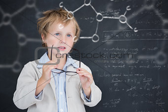 Composite image of cute pupil holding glasses