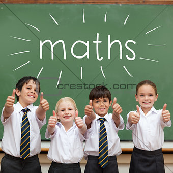 Maths against cute pupils showing thumbs up in classroom
