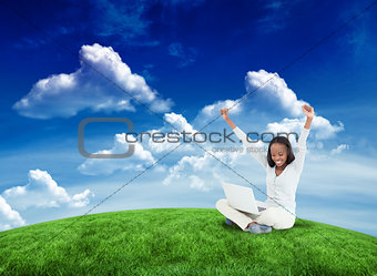 Composite image of young woman stretching while on the floor with her laptop