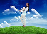 Composite image of side view of young woman carrying a pile of books