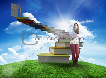 Composite image of smiling student holding textbook